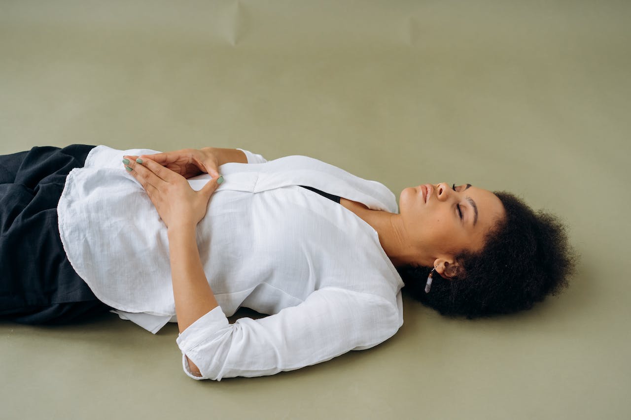 Woman in White Long Sleeve Shirt Lying on Floor